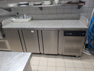 une cuisine avec des placards et des plans de travail en inox