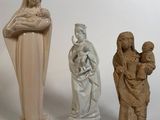 trois figurines représentant une femme tenant un enfant dans ses bras et une statue représentant une femme tenant un enfant dans ses bras