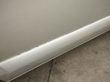 a picture of a white car with a hole in the side of it