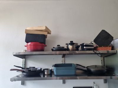 many pots and pans on the shelves in the kitchen