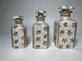 three small vases with floral designs on them sitting next to each other