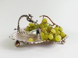 a silver plate with a bunch of grapes on it