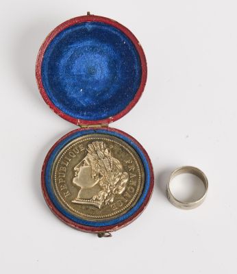 une image représentant une pièce de monnaie dans un étui contenant une bague