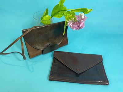 a small purse and a small wallet on a blue surface