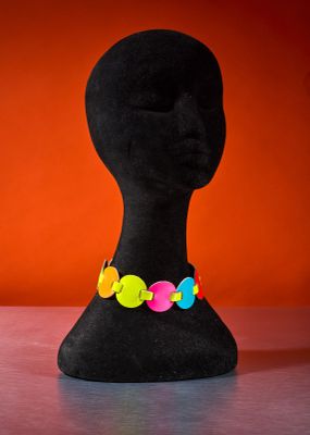 a close up of a mannequin head on a table with a red background