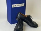 the black shoes are next to a blue box on a white surface