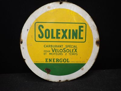 un vieux panneau jaune et vert sur un fond noir