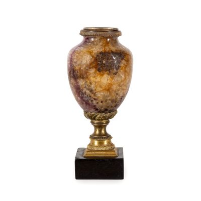 une photo d'un vase posé sur un socle, sur fond blanc