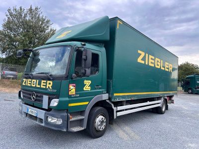 un camion vert garé sur un parking
