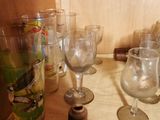 bottles and glasses on a counter with a spool of thread