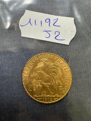a close up of a gold coin with a tag on it