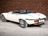 an image of a white sports car parked in front of a brick wall