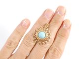 an image of a woman ' s hand holding a ring with a turquoise stone on it