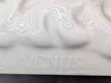 a white porcelain sculpture of a horse on a table