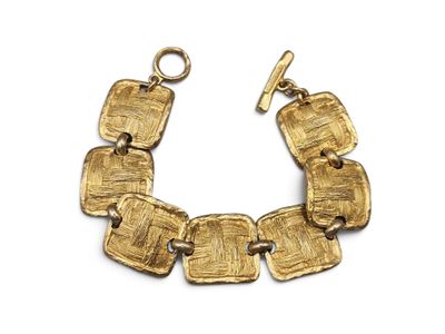 a close up of a gold bracelet on a white background