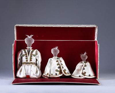 two dolls are in a box with a red cloth