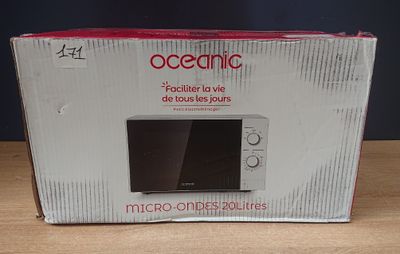 emballage d'un four à micro-ondes posé sur une table devant un mur bleu