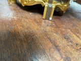 a gold clock sitting on a wooden table