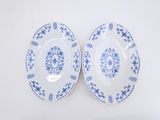 two blue and white plates on a white surface