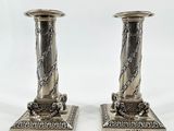 paire de bougeoirs plaqués argent avec des chaînes sur les socles