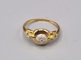 gros plan d'une bague en or et diamants sur une surface blanche