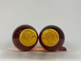 pair of red and gold glass beads on a white surface