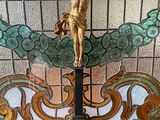 a statue of jesus on a cross in front of a stained glass window