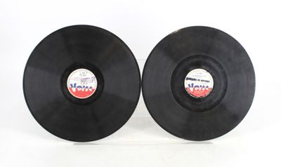 two black vinyl records sitting on top of each other on a white surface