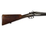 un vieux fusil avec un canon en bois et une poignée en bois