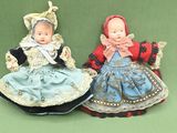two dolls that are sitting on a green surface