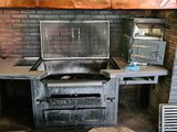 a grill in the middle of a kitchen with a brick wall