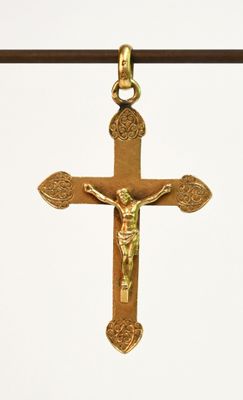 une croix en or suspendue à un fil sur lequel est fixée une croix