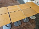 four wooden tables with metal bases sit on a wooden table