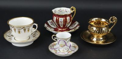 quatre tasses et soucoupes posées sur une surface noire