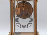 a clock that is sitting on a stand on a white surface