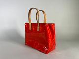 a close up of a red bag on a white surface