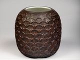 a brown vase that is sitting on a white surface