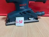une ponceuse orbitale Bosch posée sur une table, avec son étiquette de prix