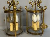 une paire de lanternes en laiton et en verre contenant des bougies