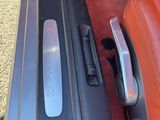 une photo d'une poignée de portière de voiture avec un intérieur rouge