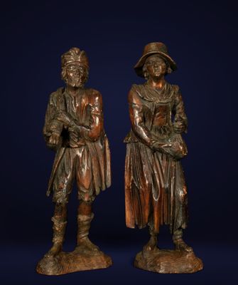 a pair of bronze figures of a man and a woman standing next to each other