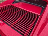 the rear end of a red sports car parked on the side of the road