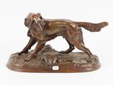 bronze statue of a dog on a rock on a white background