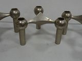 three silver metal candles are sitting on a white surface