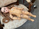 a doll that is laying on a chair with a baseball mitt