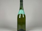 an empty bottle of wine sitting on top of a white table