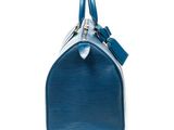 a close up of a blue handbag on a white background