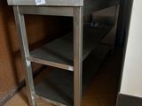 une table en métal avec un plateau en verre dans une cuisine