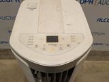 a white air conditioner sitting on the floor