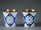deux coupes bleues et blanches avec des bords dorés sur une surface grise